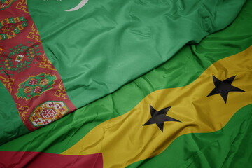 waving colorful flag of sao tome and principe and national flag of turkmenistan.