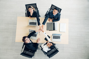 Top view Stack of hands symbolizing trust and cooperation, Group of professional business people are working in conference room.