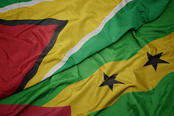 waving colorful flag of sao tome and principe and national flag of guyana.