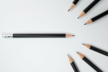 Black wood pencils, Black wood pencil turn the head of the pencil towards to group of black pencil with white background, Copy space, School and office concepts, Painting and education concepts.