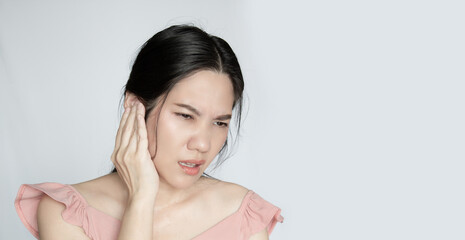 Asian beautiful woman covering her ear felling nervous and pain. Healthy life .