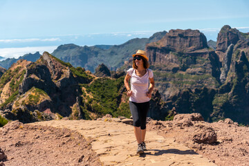 Naklejka premium A tourist walking on the trekking trail at Pico do Arieiro in summer, Madeira. Portugal