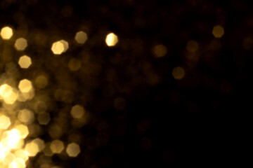 Golden blurred bokeh lights on black background. Glitter sparkle stars for celebrate. Overlay for...