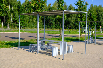 Rest area for motor travelers Poland. A bench with a table with a roof. Expressway stop. Large Parking with light but without cars on the track on a summer.