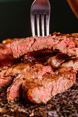 Fetta di carne cotta al sangue sulla brace e servita su una pietra ollare bollente in un ristorante