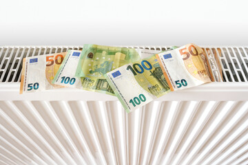Euro banknotes on home heating radiator. Energy crisis and expensive heating costs for winter...