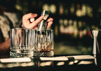 Bartender pouring whiskey on glass in bar