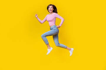 Fototapeta na wymiar Full body photo of gorgeous young lady excited running fast hurry sales dressed trendy striped outfit isolated on yellow color background
