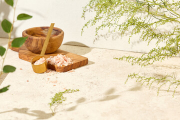 Light background with spa elements and green leaves. Spa mockup with wooden board and sea salt. Eco...