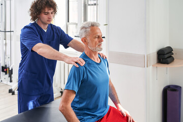 Obraz premium Young specialist working with his old patient at the hospital