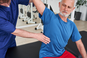 Obraz premium Elderly man having back massage in medical office