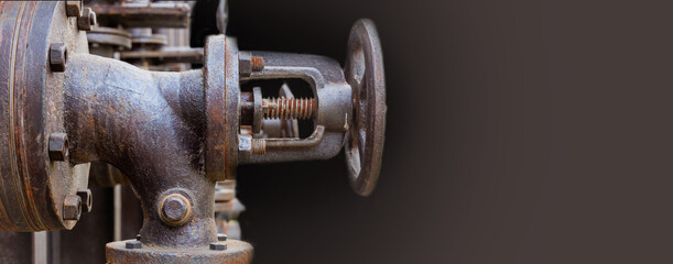 Industrial, machine scene. Steel, rusty valve and bolts on a dark background. Banner Copy space