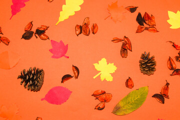 creative autumn background with autumn leaves, pine cones, and decorative husks
