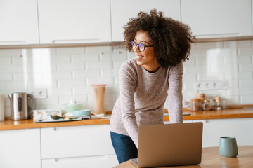 African american young woman with afro hairstyle using laptop at home