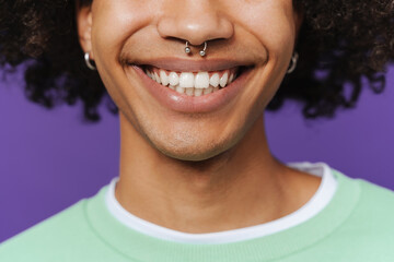 Young caribbean man with piercing smiling and looking at camera