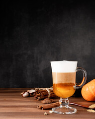 Pumpkin spice latte in a glass mug with cinnamon and ginger