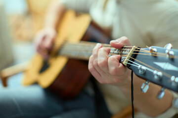 Talented guy professional musician composer play acoustic guitar performing music closeup. Male...