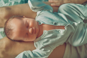 A newborn baby is lying on his mother's lap