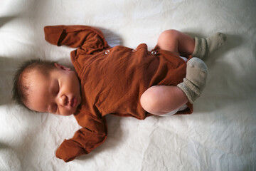 A newborn baby lying in his crib top view