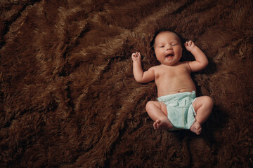 portrait of a newborn baby lying on a brown fur blanket