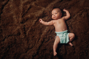 portrait of a newborn baby lying on a brown fur blanket