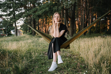 beautiful young girl resting in hammock in nature
