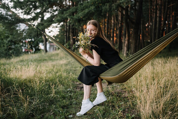 beautiful young girl resting in hammock in nature
