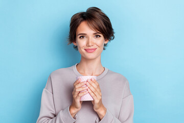 Photo of pretty cute lovely positive lady dressed trendy outfit sweatshirt raise two arm hold glass water isolated on blue color background