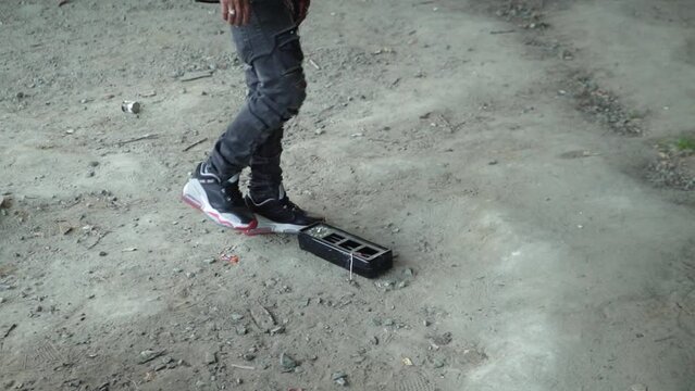 Man kicking an old broken clock that lays on the floor.