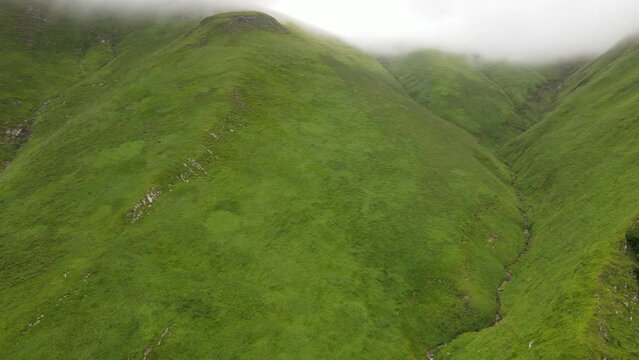 Fresh green hills and chilly clouds surrounding Arpea Cave, Pyrenees.