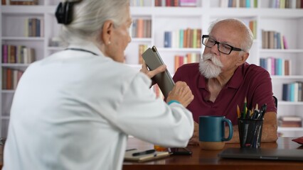 Nurse doctor in white coat talking to older patient, comforting elderly man after bad news, upcoming treatment of incurable disease, provide support, give psychological aid, tell hopeful words
