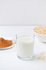 glass of milk oats granola and chocolate on a plate. White background. healthy food. diet.