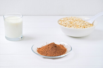 plate of oatmeal and cocoa carob and a glass of milk. healthy food. diet.