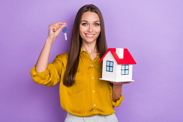 Photo of funny millennial lady hold house key wear yellow shirt isolated on purple color background