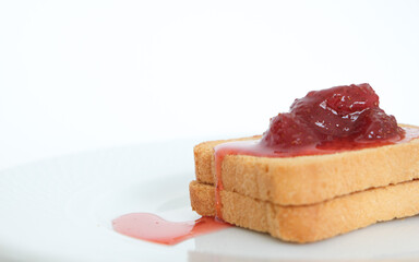 Homemade strawberry jam above toast bread with plate. Breakfast concept. Selective focus. Copy space area.