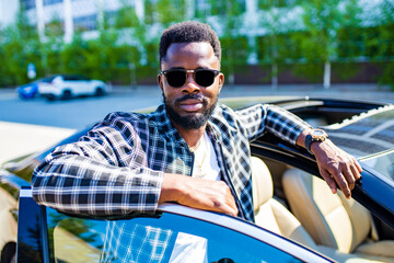latin hispanic man in a stylish plaid suit wear glasses in luxury sports car