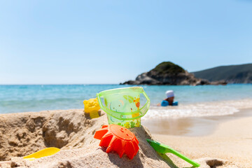 Children plastic toys using playing on sand at beach. Summer, vacation time and child development