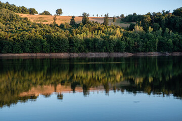 Naklejka na ściany i meble Reflets des arbres d'une forêt sur l'eau d'un lac. 