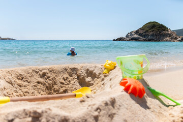 Fototapeta na wymiar Children plastic toys using playing on sand at beach. Summer, vacation time and child development