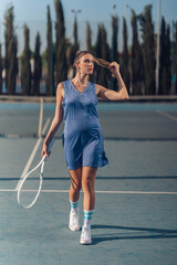 Chica joven en traje de tenis sobre la cancha copn raqueta blanca