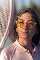 Chica joven con septum y conjunto de tenis rosa en cancha de tenis con raqueta
