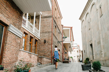Tourist, man and daughter walking back  down old the Old streets of central Tbilisi, Georgia. Architecture in the Old Town of Tbilisi, capital of Georgia, on a spring day.