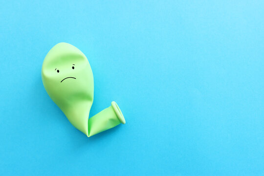 Top view image of balloon with sad face over blue background. Concept of emotions and sadness or stress
