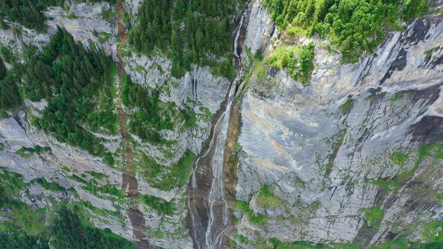 Landscape of Lauterbrunnen valley, the Aegertenbach falls and the Lauterbrunnen Wall in Swiss Alps, Switzerland.