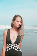 Beautiful caucasian woman in green bikini on tropical beach.
