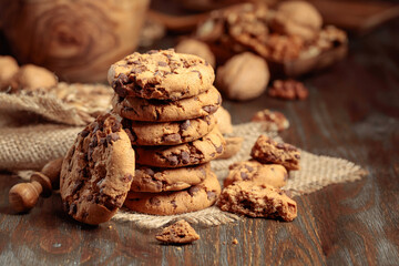 Chocolate cookies on a wooden table with kitchen utensils.