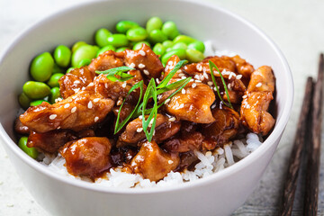 Teriyaki chicken with rice and edamame beans in gray bowl. Japanese cuisine.