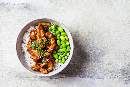 Teriyaki chicken with rice and edamame beans in gray bowl. Japanese cuisine.