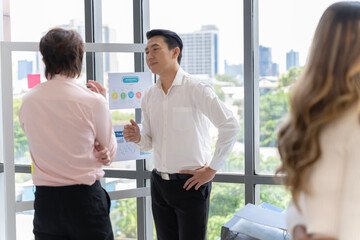 A group of Asian businessmen in casual wear are having a meeting to present their ideas on how to run a sustainable small business SME