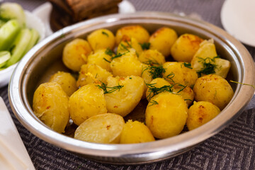 toasted young potatoes with dill in metal skillet